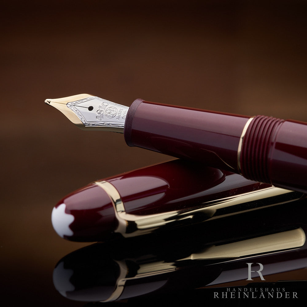 Detailaufnahme der Feder des burgunderroten Montblanc Füllers auf der Kappe liegend