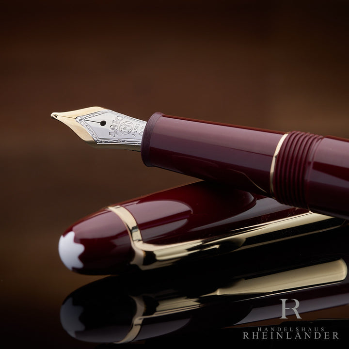 Detailaufnahme der Feder des burgunderroten Montblanc Füllers auf der Kappe liegend