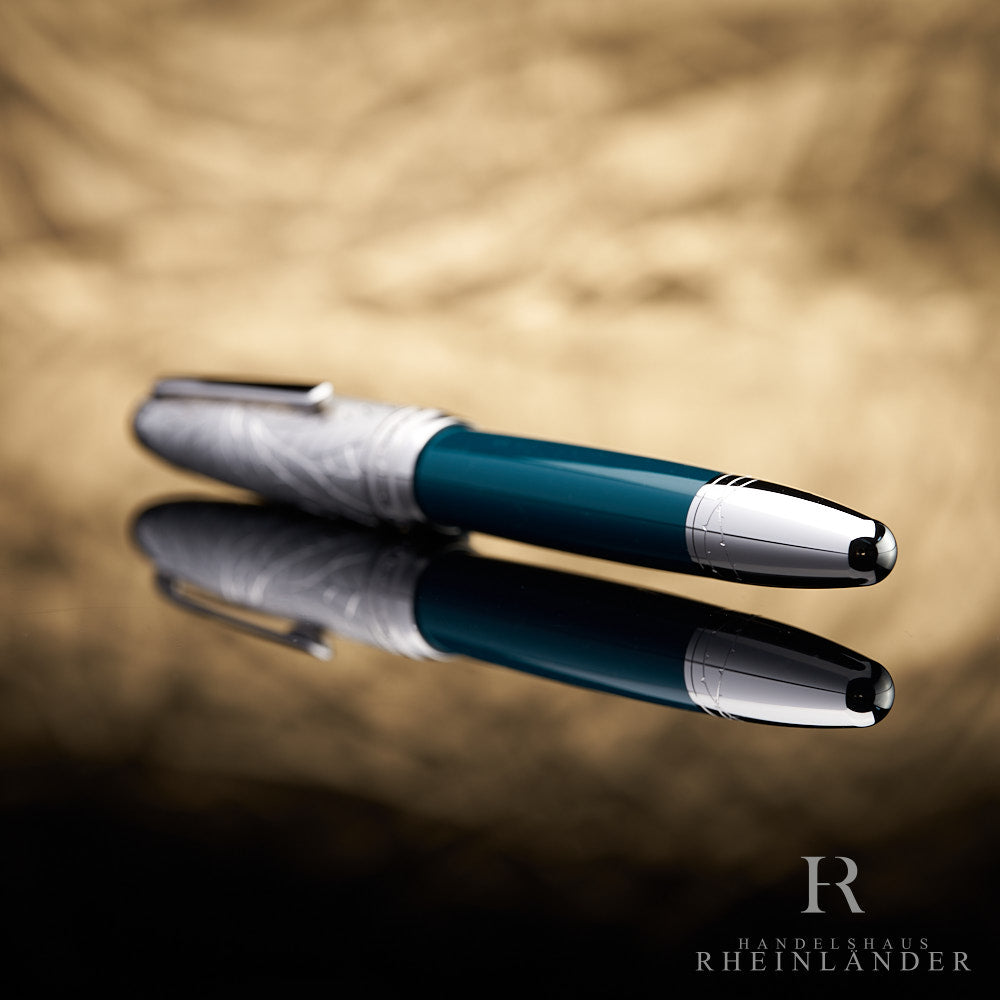 grüner Schaft mit silbernem Konus des Montblanc Doue LeGrand Romeo & Juliet Rollerball liegend vor goldenem Hintergrund