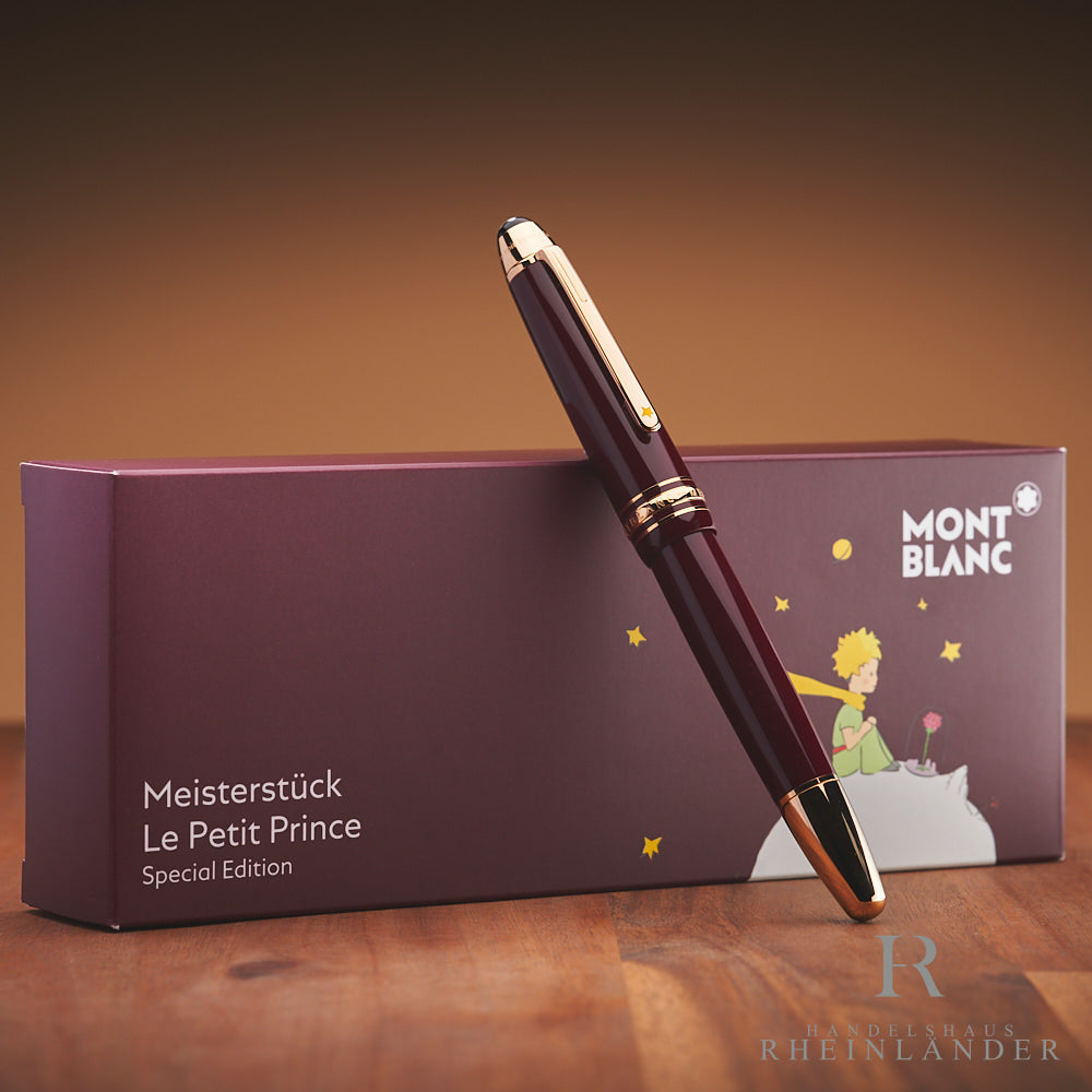 bordeaux-roter Montblanc Petit Prince Füllfederhalter angelehnt an die Originalverpackung vor braunem Hintergrund