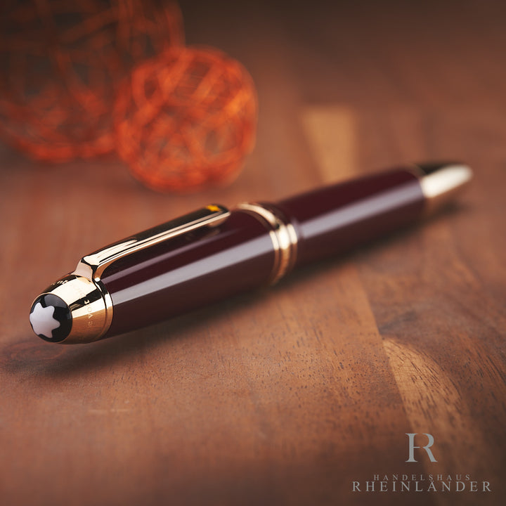 goldener Kappenkopf mit Montblanc Emblem des LeGrand Petit Prince Füllfederhalters auf Holz liegend