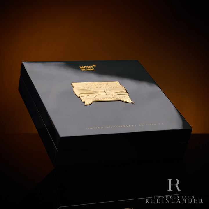 schwarze Originalschatulle mit goldener Plakette des Montblanc Limited Edition 75 Anniversary Kugelschreibers vor dunklem Hintergrund
