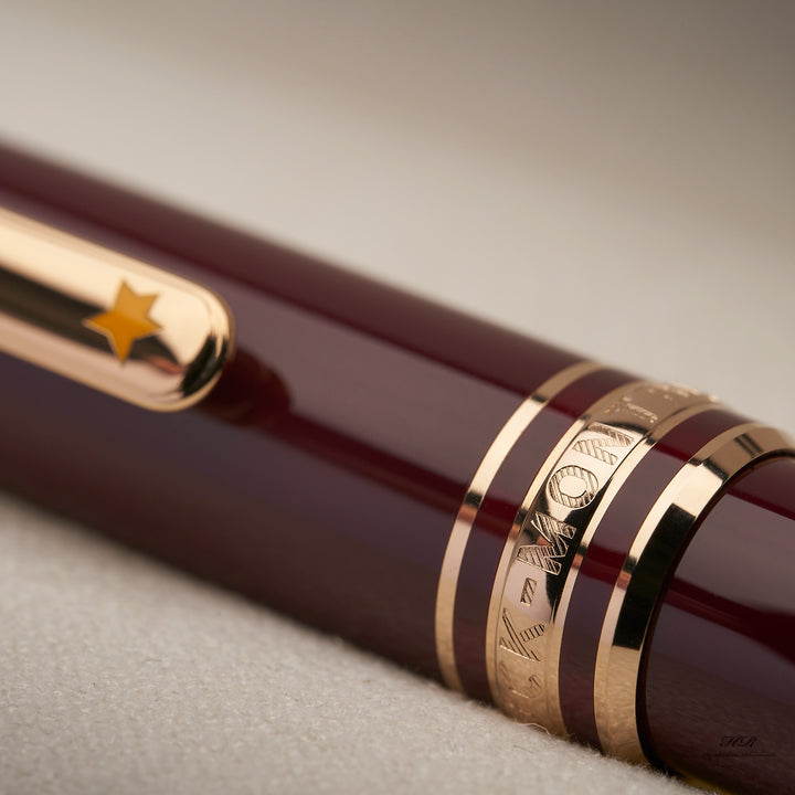 Nahaufnahme der Kappenringe mit Gravur und gelbem Lack-Stern auf dem Clip des Montblanc Petit Prince Rollerballs