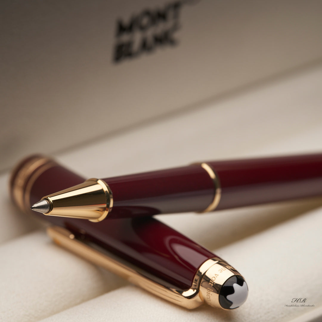 offener bordeauxroter Montblanc Petit Prince Rollerball mit goldenen Beschlägen auf der Kappe abgelegt 