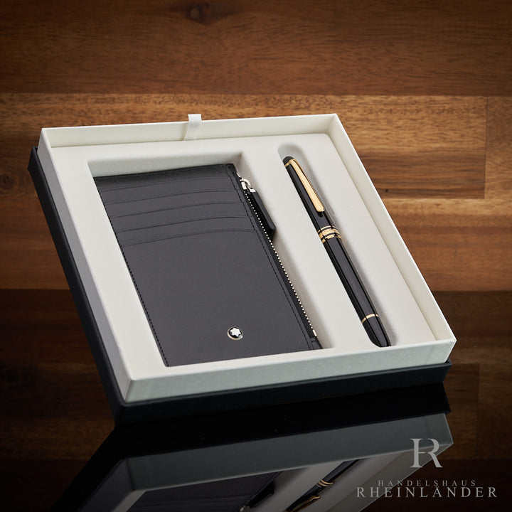 Montblanc Rollerball und Kartenetui in offener Originalverpackung schräg vor hölzernem Hintergrund