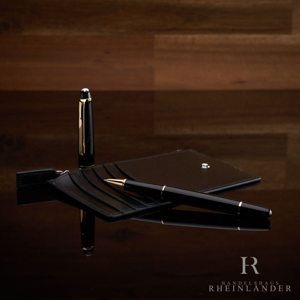 Montblanc Kartenetui liegend mit offenem Rollerball und stehender Kappe auf schwarzem Tisch