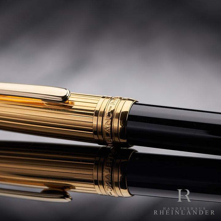goldenen Kappenringe mit Gravuren des Montblanc Solitaire Doue Gold Plated Drehbleistifts vor silbernem Hintergrund