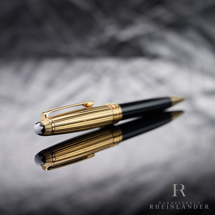goldener Kappenkopf mit Emblem des Solitaire Doue Gold Plated Drehbleistift liegend vor silbernem Hintergrund
