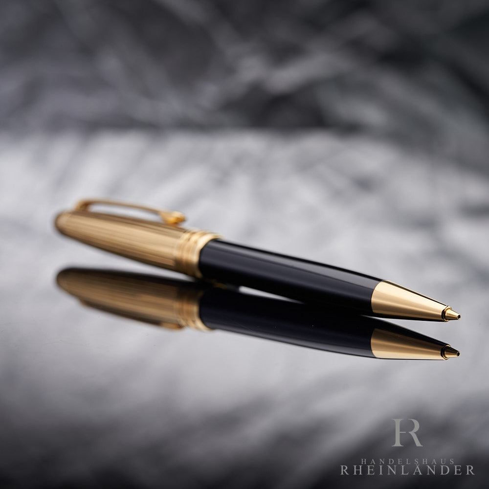 goldene Spitze des Montblanc Solitaire Doue Gold Plated Drehbleistifts liegend vor silbernem Hintergrund