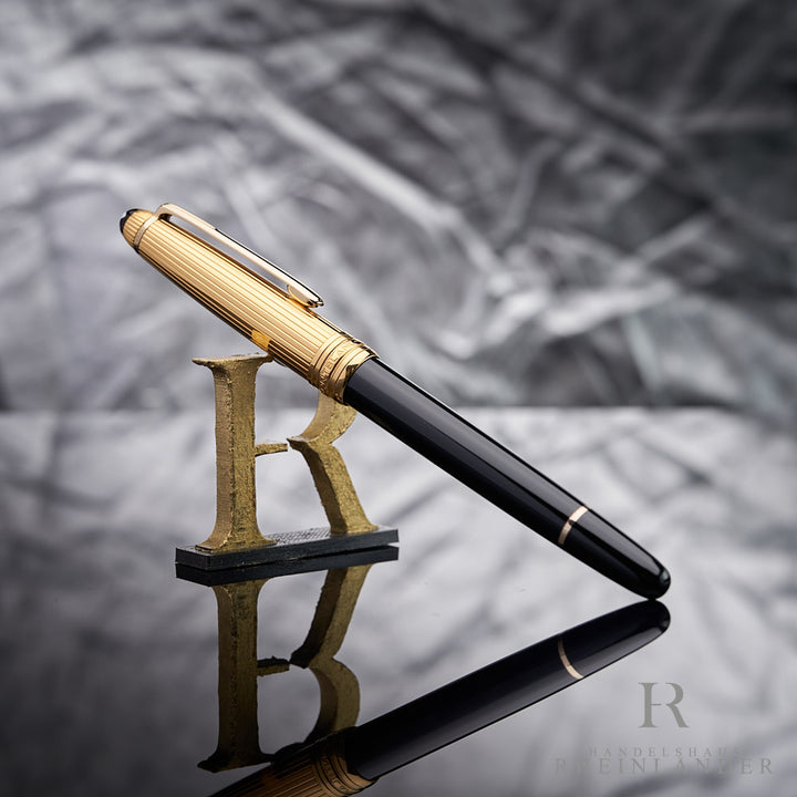 schwarz goldener Montblanc Doue Rollerball angelehnt an das Handelshaus Rheinländer Logo vor silbernem Hintergrund