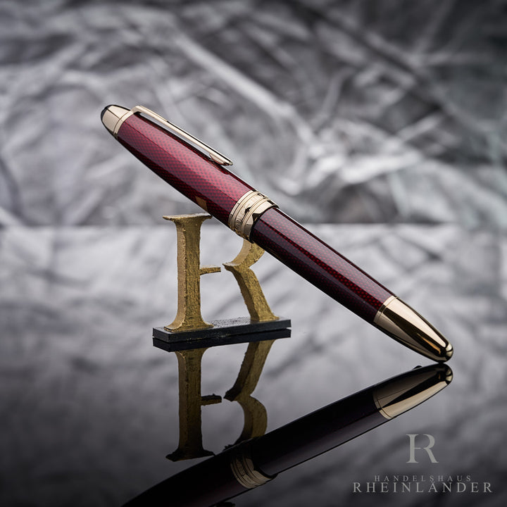 roter Montblanc Solitaire Golden Hour Füllfederhalter angelehnt an das Handelshaus Rheinländer Logo vor grauem Hintergrund