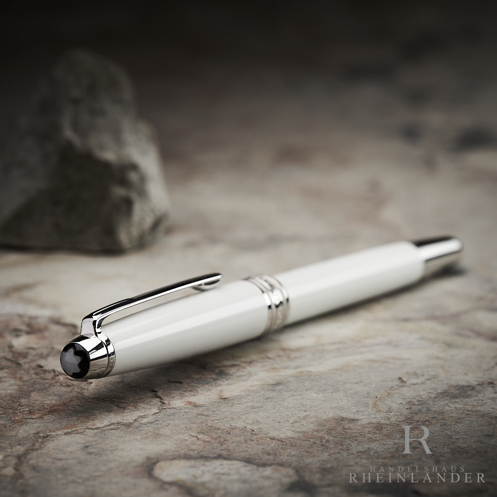 Kappenkopf mit Perlmutt Montblanc Emblem des Solitaire Tribute to the Mont Blanc Rollerball liegend auf steinernem Untergrund
