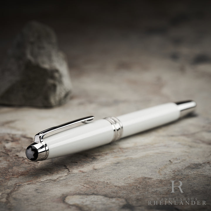 Kappenkopf mit Perlmutt Montblanc Emblem des Solitaire Tribute to the Mont Blanc Rollerball liegend auf steinernem Untergrund