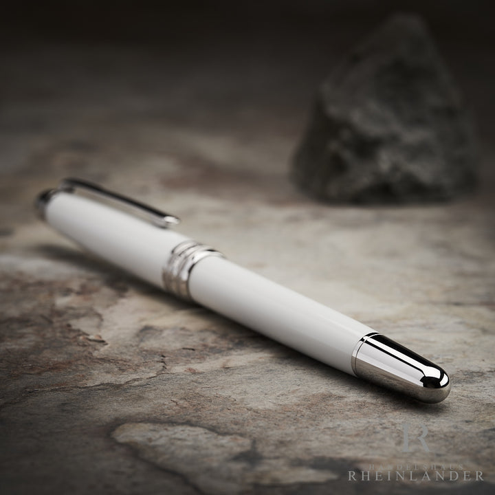 silberner Konus und weißer Schaft des Montblanc Solitaire Tribute to the Mont Blanc Rollerballs auf grauem Grund liegend