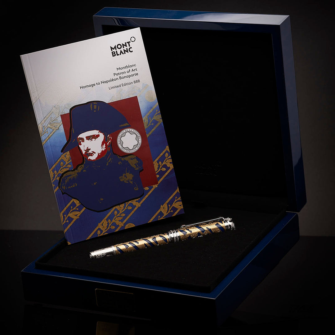 Mehrfarbiger Füller neben aufgestelltem Editionsheft in Originalbox liegend fotografiert