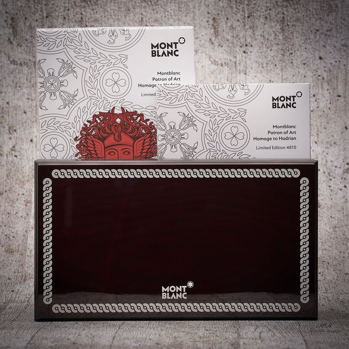 Originalverpackung des Montblanc Patron of Art Hadrian 4810 Füllers stehend mit Begleitheft vor grauem Hintergrund