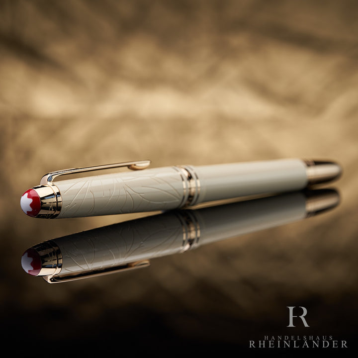 goldener Kappenkopf mit rotem Montblanc Emblem am beigen Romeo & Juliet Füllfederhalter liegend vor goldenem Hintergrund