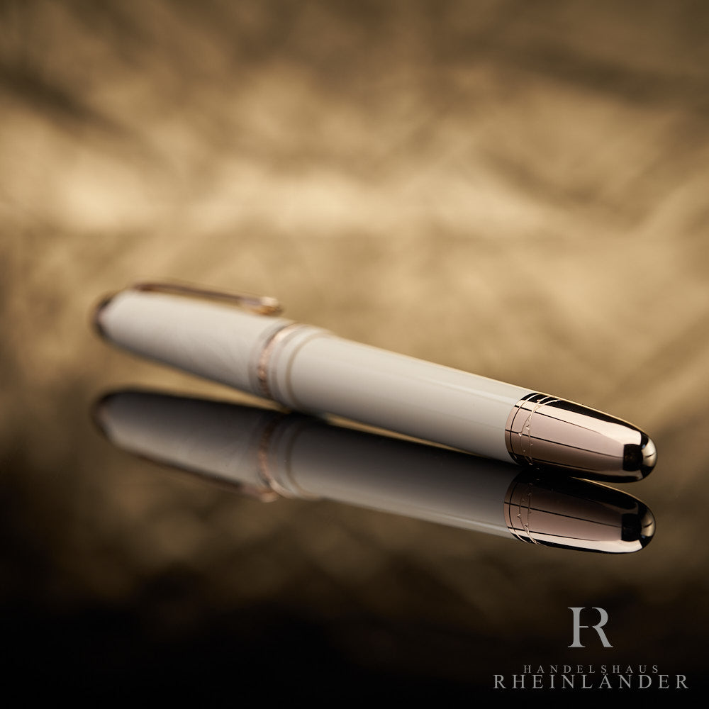 goldener Konus des beigen Montblanc Romeo & Juliet Füllfederhalters liegend vor goldenem Hintergrund mit Reflektion