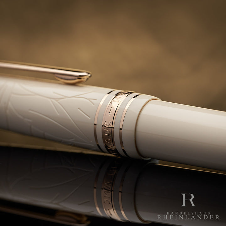 Nahaufnahme der goldenen Kappenringe des beigen Montblanc Romeo & Juliet Füllfederhalters mit feinen Gravuren