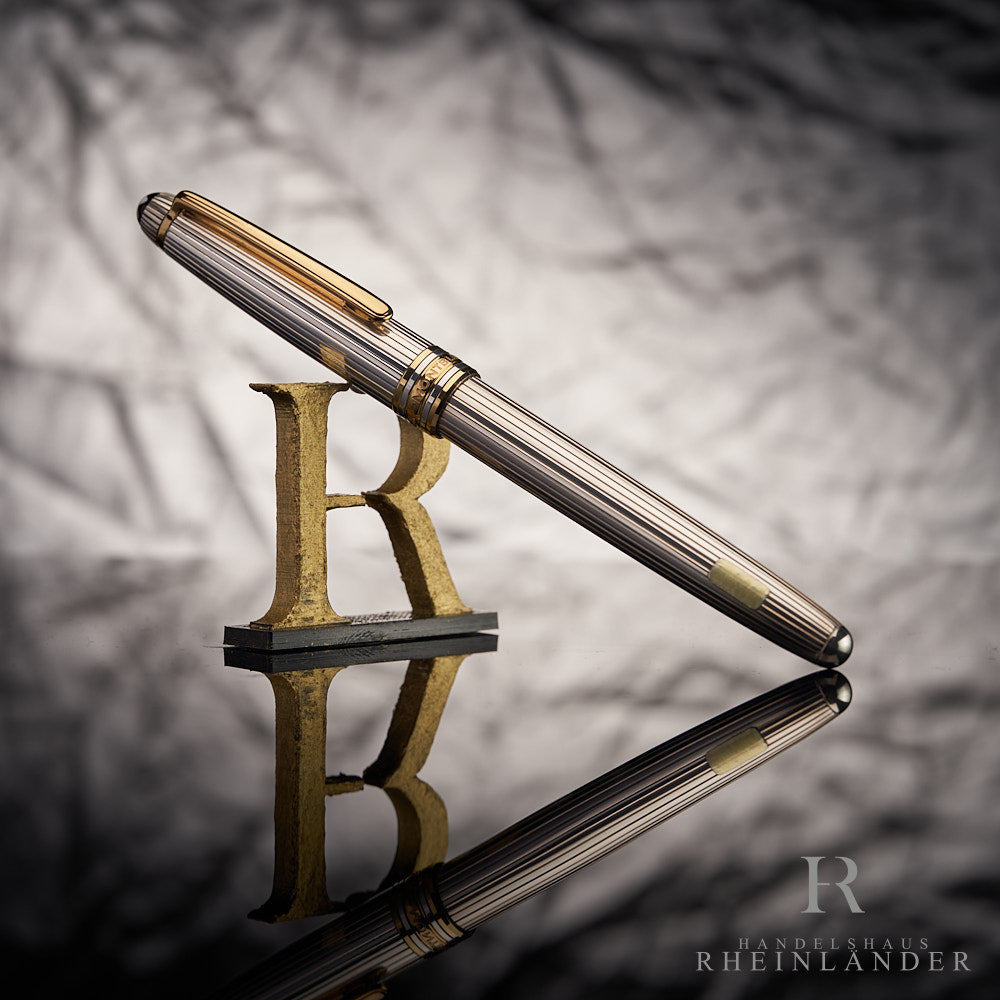 Silberner Füller von Montblanc mit Pinstripes und goldenen Beschlägen halb-stehend fotografiert