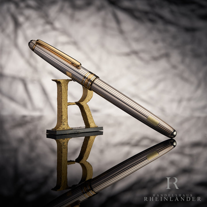 Silberner Füller von Montblanc mit Pinstripes und goldenen Beschlägen halb-stehend fotografiert