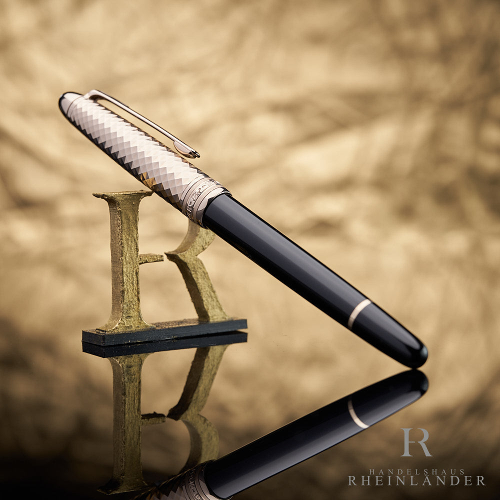 schwarz-goldener Rollerball mit geometrischem Muster auf der Kappe an das HR Logo angelehnt vor goldenem Hintergrund