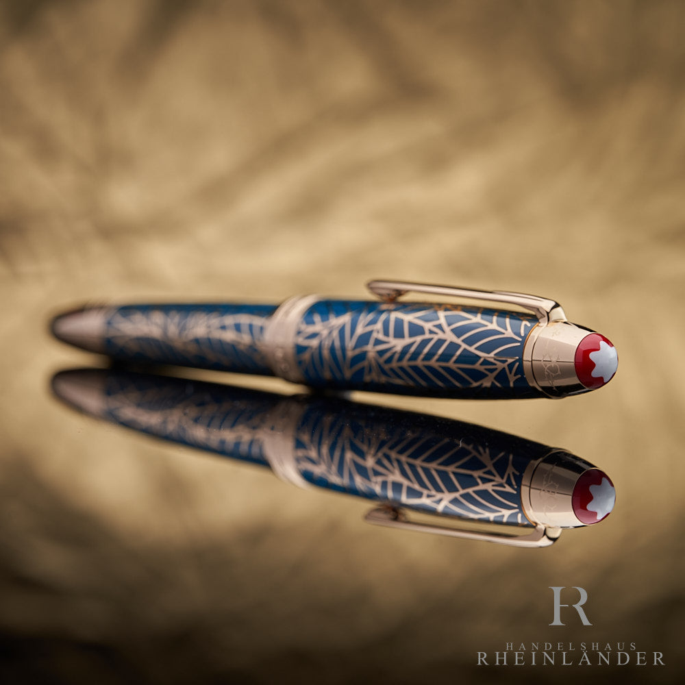 goldene Kappe mit blauem floralen Muster aus Lack auf dem Montblanc Solitaire Romeo & Juliet Rollerball liegend mit Reflektion 