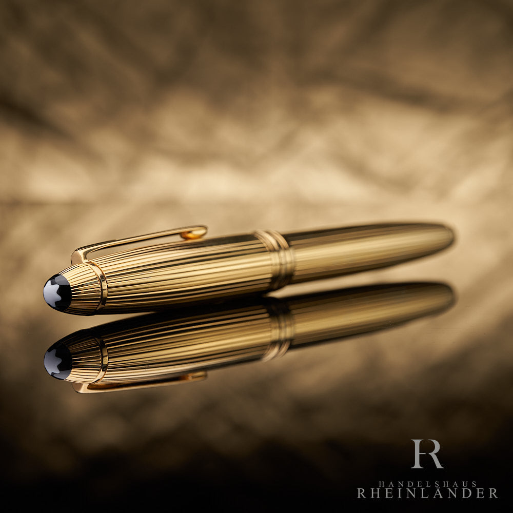goldener Kappenkopf des Montblanc LeGrand Vermeil Rollerball mit Montblanc Emblem liegend vor goldenem Hintergrund