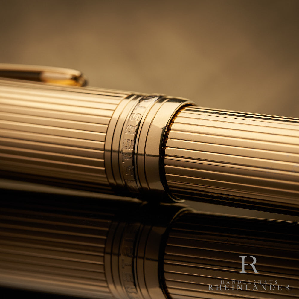Nahaufnahme der goldenen Kappenringe des Montblanc LeGrand Vermeil Rollerballs mit Gravuren und Fadenguilloche