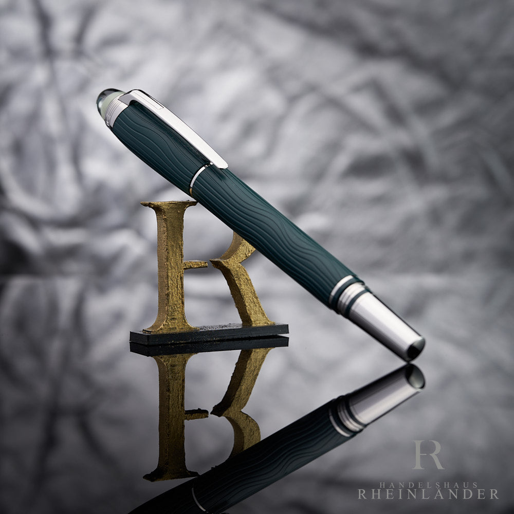 Dunkelgrüner Rollerball mit Liniendesign vor grauem Hintergrund auf R-Letter lehnend fotografiert