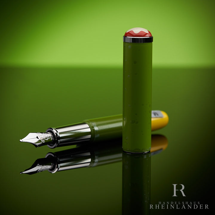 Grüner Montblanc Füller "Schreiberling" offen liegend mit danebenstehender Kappe vor grünem Hintergrund