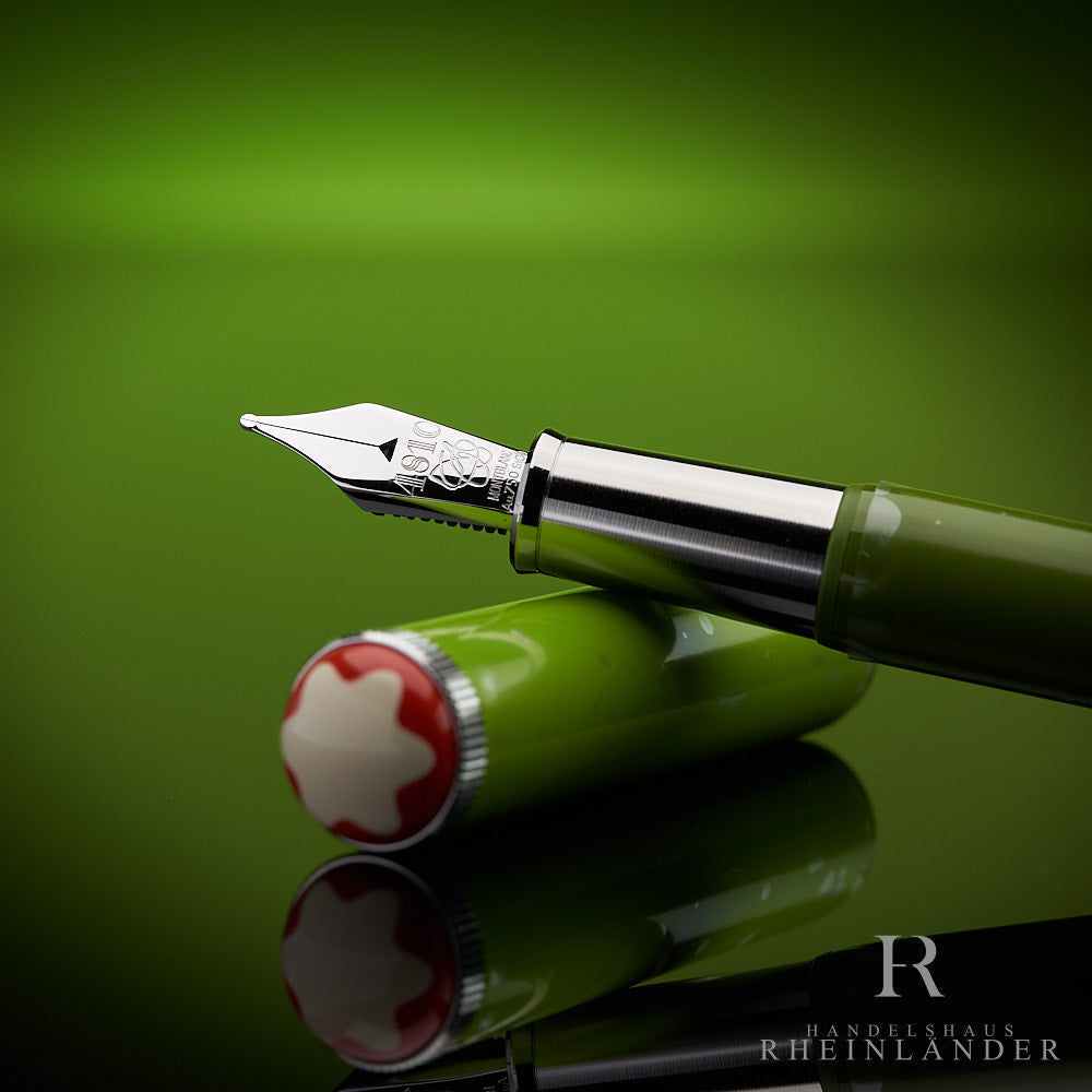 Detailaufnahme der Feder des Montblanc Schreiberling Füllers auf der Kappe abgelegt vor grünem Hintergrund