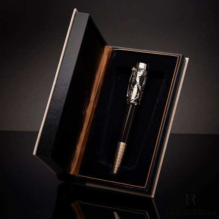 offene Buchverpackung mit schwarz-goldenem Montblanc Carlo Collodi Rollerball vor schwarzem Hintergrund