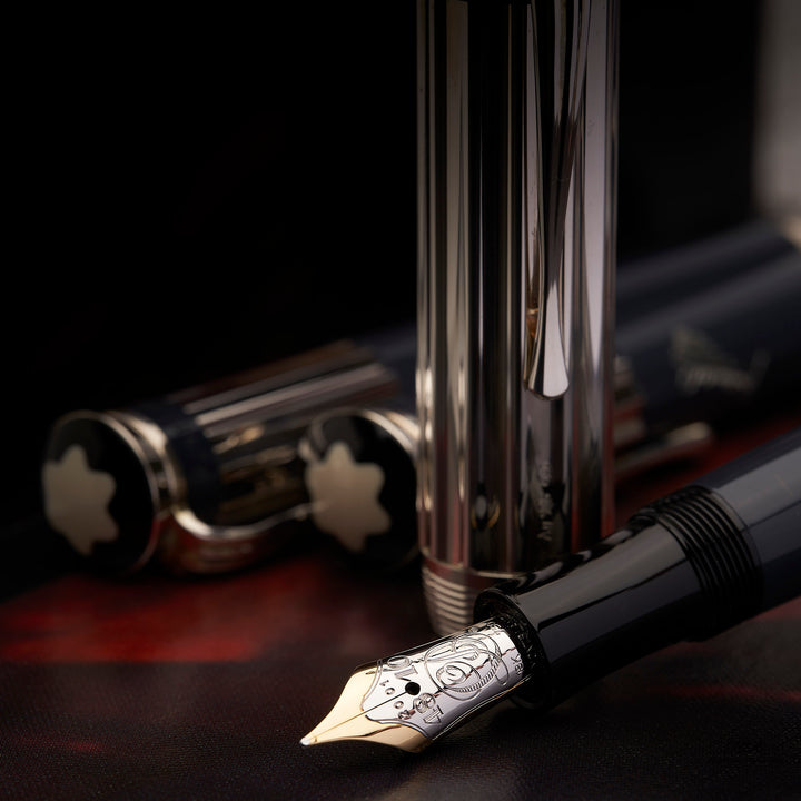 Bi-Color Goldfeder des Montblanc Charles Dickens Füllfederhalters mit silberner Kappe dahinter stehend