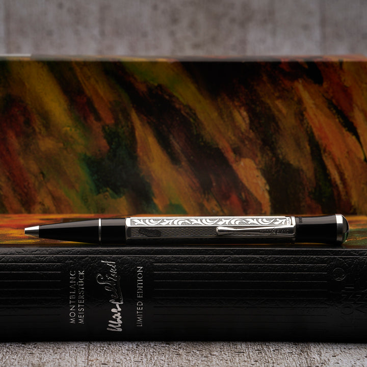 Silberner Kugelschreiber liegt im Profil auf seiner Buchbox, Originalverpackung im Hintergrund